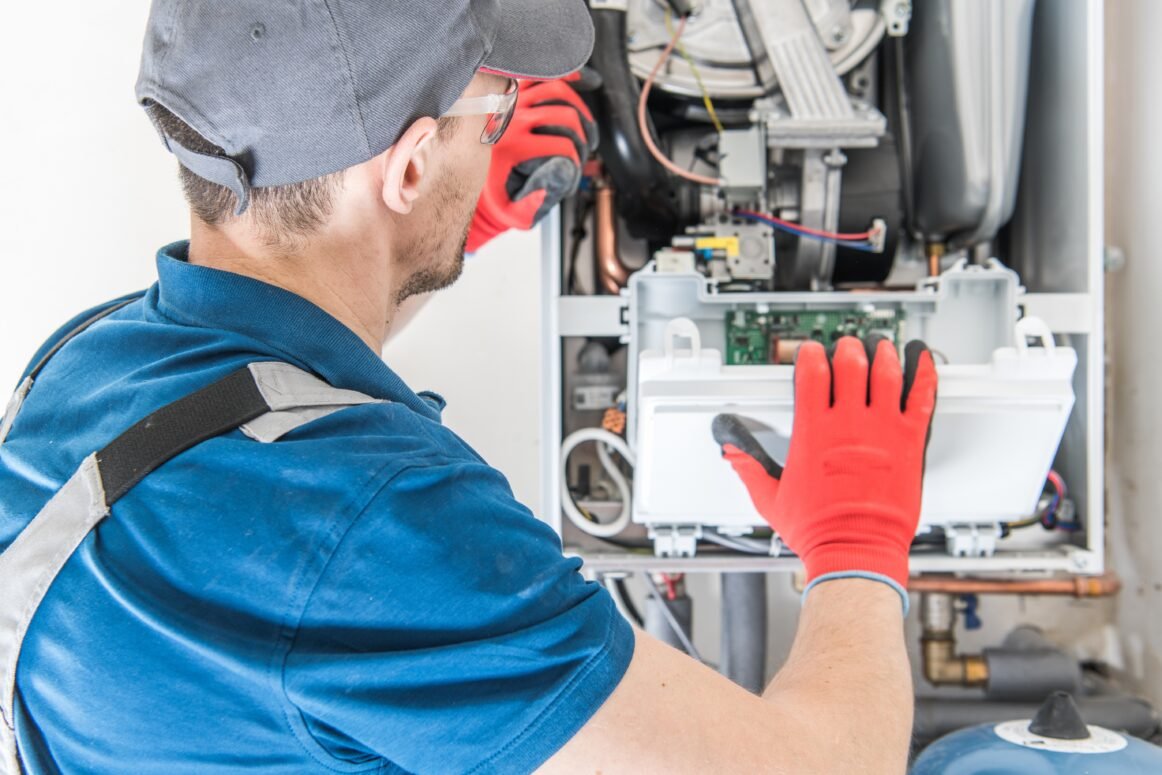 Heating Central Gas Furnace Issue. Technician Trying To Fix the Problem with the Residential Heating Equipment. furnace replacement cost